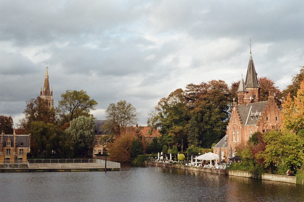 body of water near trees and buildings during day