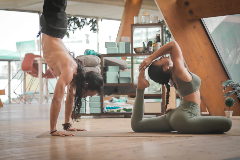 Yoga instructor guiding a student through a stretch