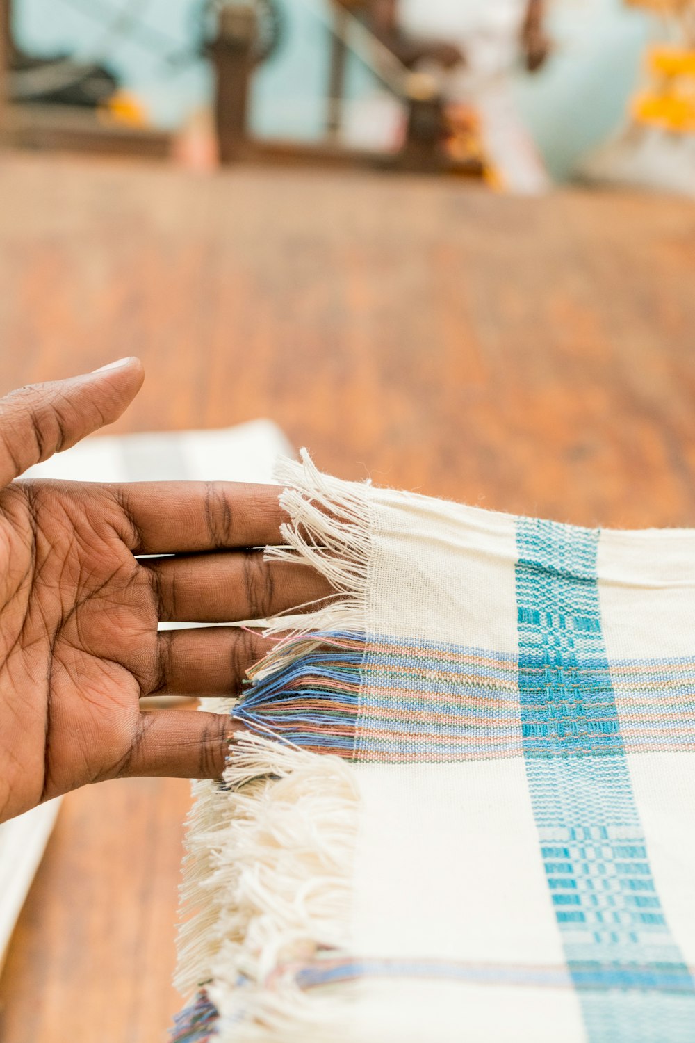 person holding white and blue fringe apparel