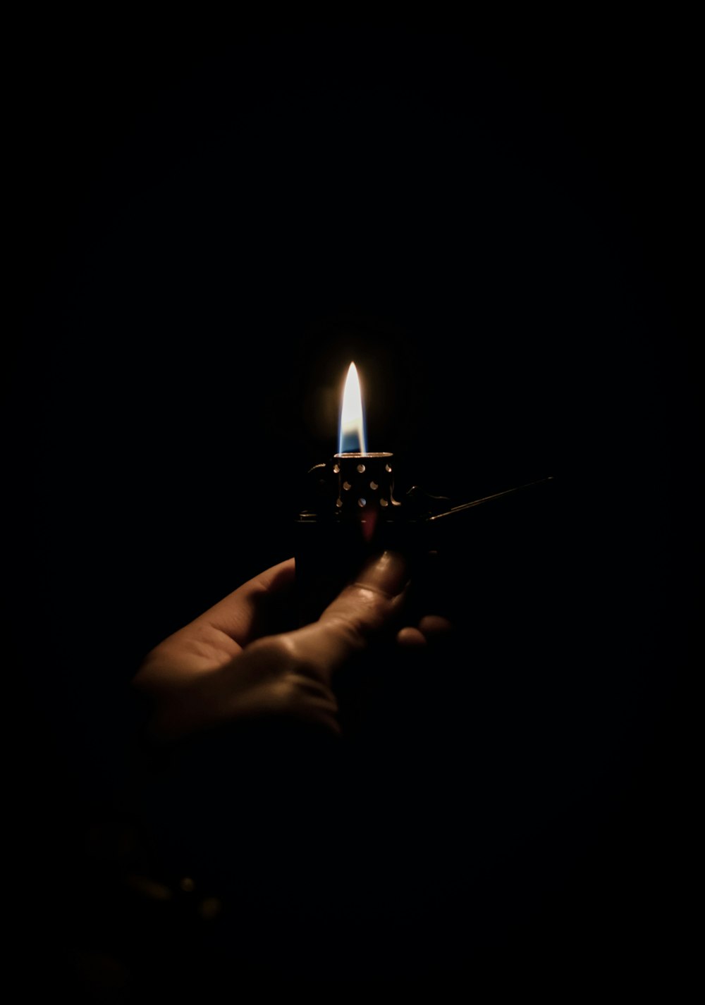 a hand holding a lighter in the dark