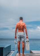man holding flippers and goggles