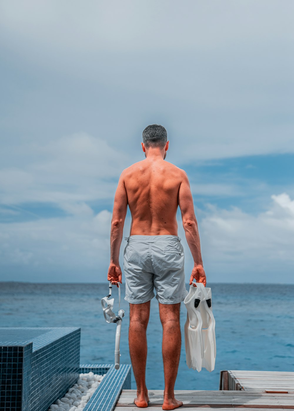 man holding flippers and goggles