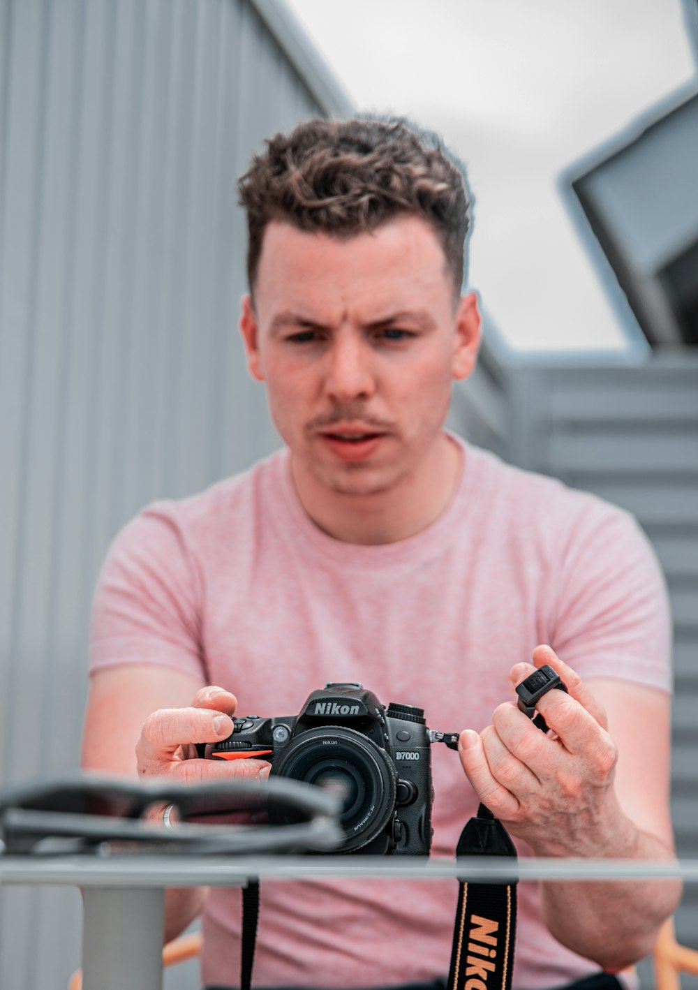 man aiming camera on sunglasses