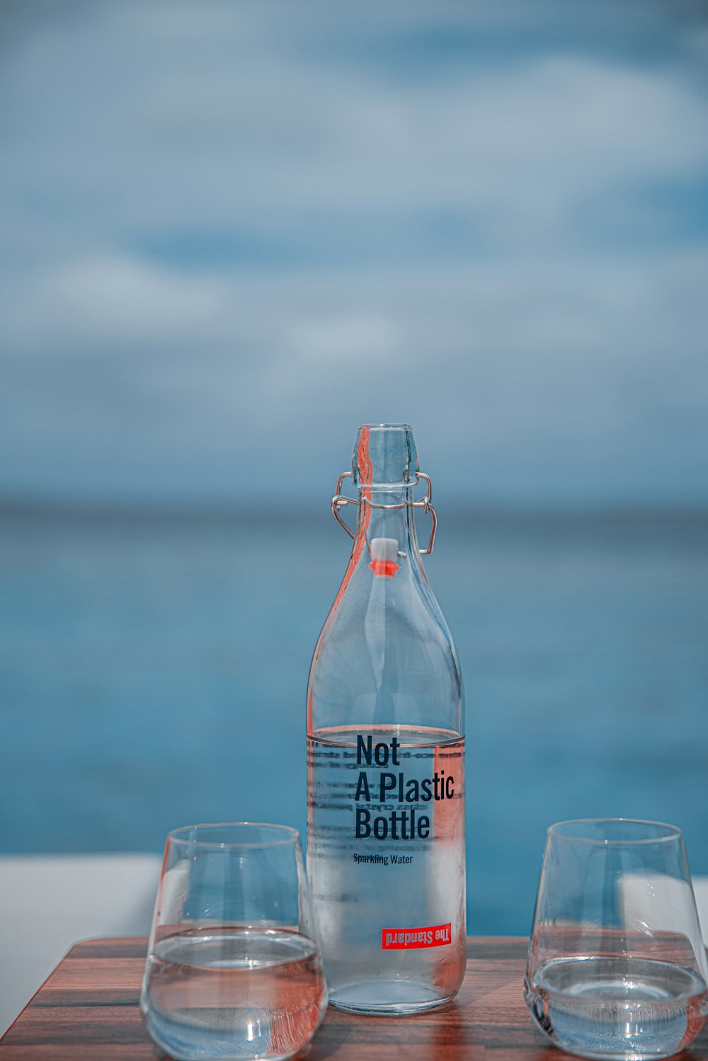 selective focus photography of plastic bottle between rock glasses during daytime