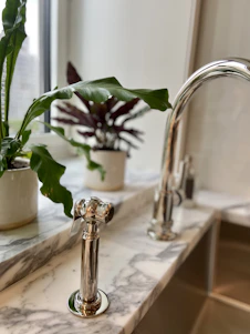 A professional cleaner carefully polishing a modern kitchen countertop with natural light streaming in.