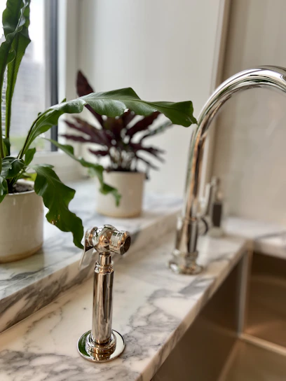 A professional cleaner carefully polishing a modern kitchen countertop with natural light streaming in.