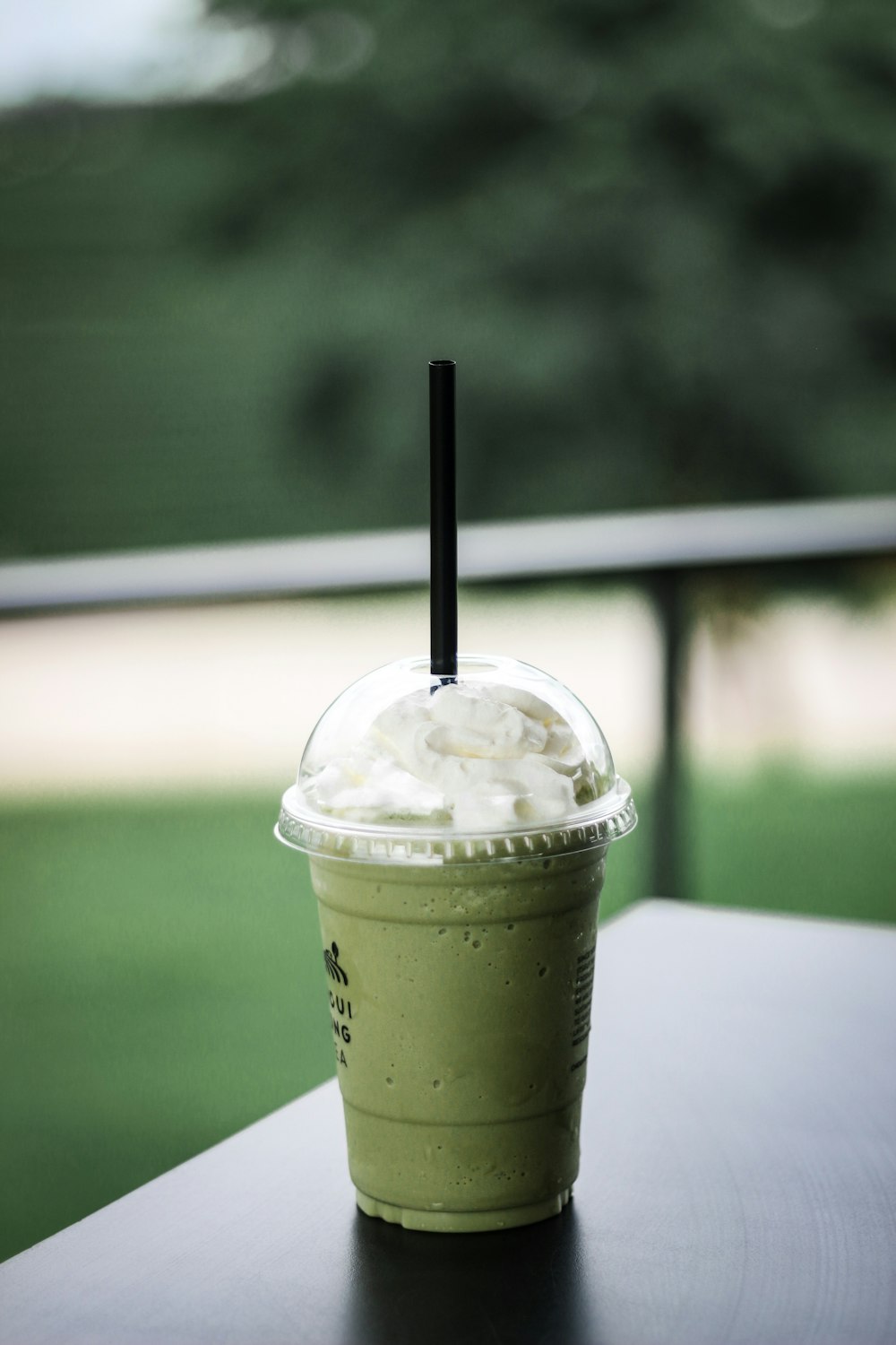 green disposable cup on black surface