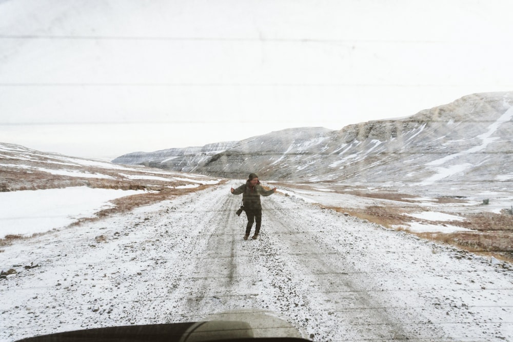woman standing on snow covered road