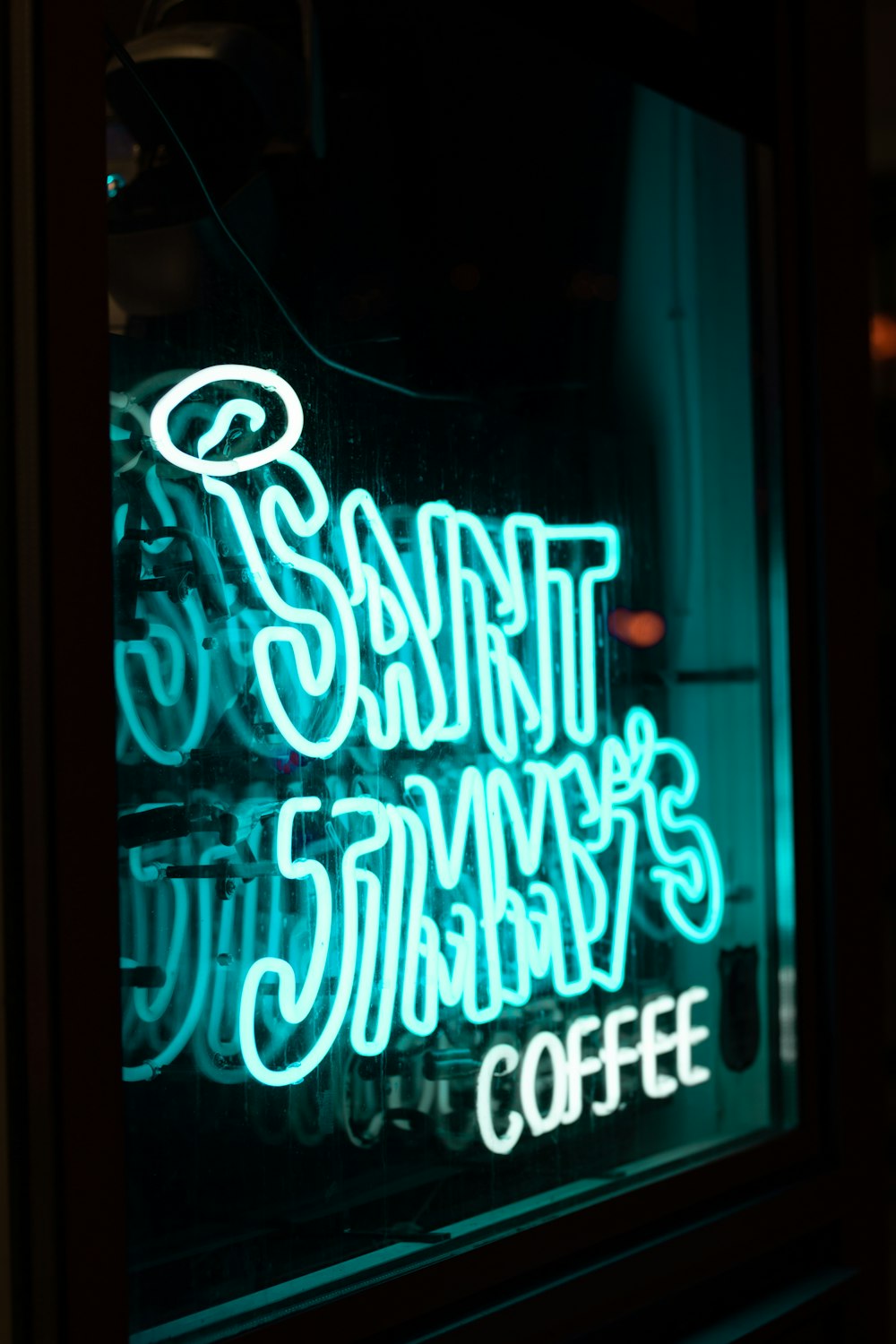 a neon sign in a window of a coffee shop