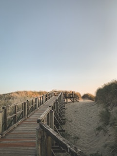 A wooden boardwalk weaving through dunes, guiding visitors to a peaceful Outer Banks beach.