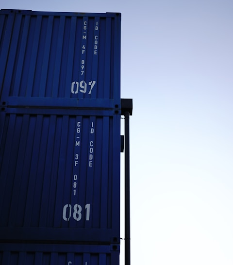 a tall blue container sitting on top of a metal pole