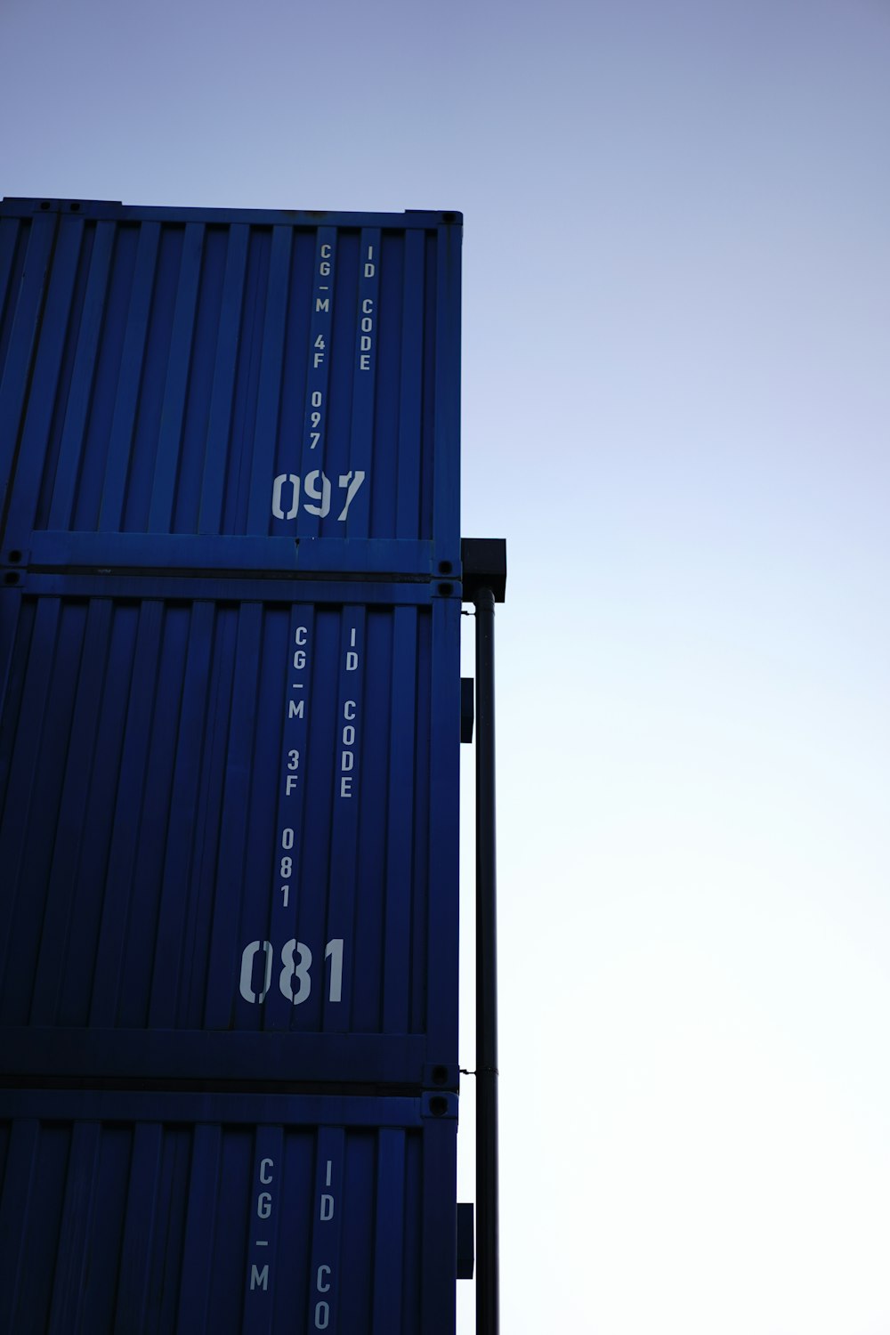 a tall blue container sitting on top of a metal pole