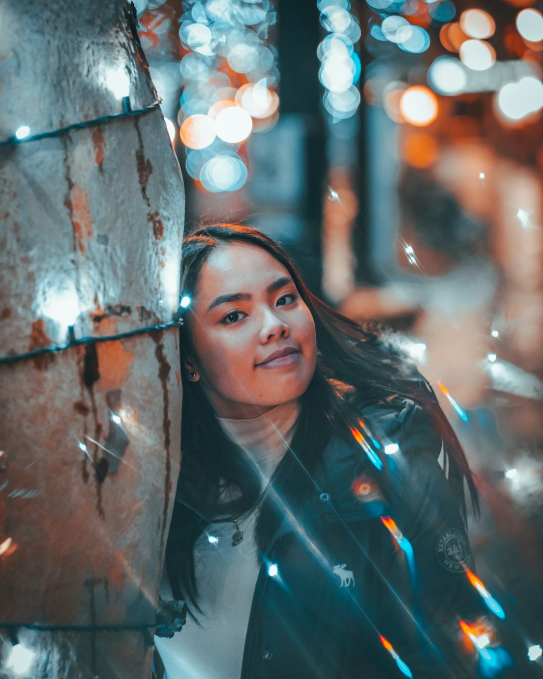 woman in black jacket standing beside tree