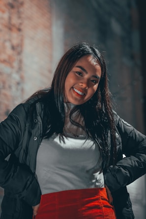 Young woman confidently posing in a black ng garments streetwear t-shirt at a vibrant urban mural.