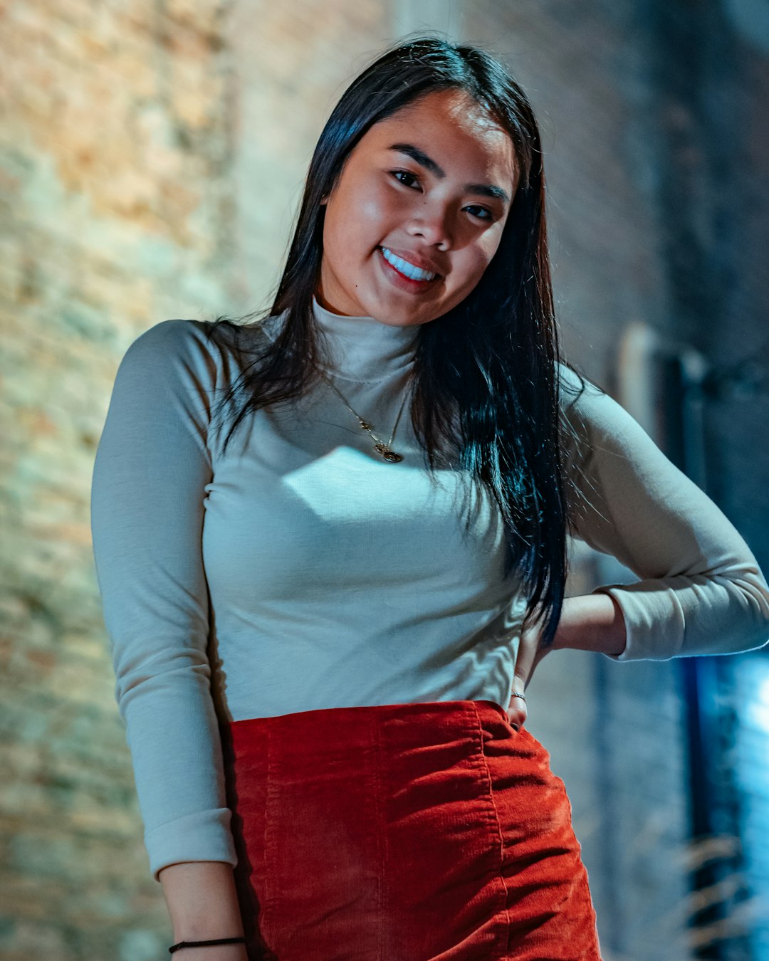 woman in white sweater standing near wall