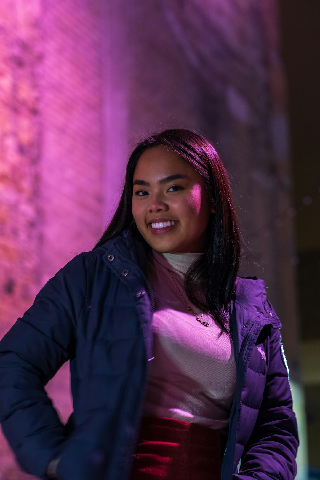 woman in blue jacket standing near wall