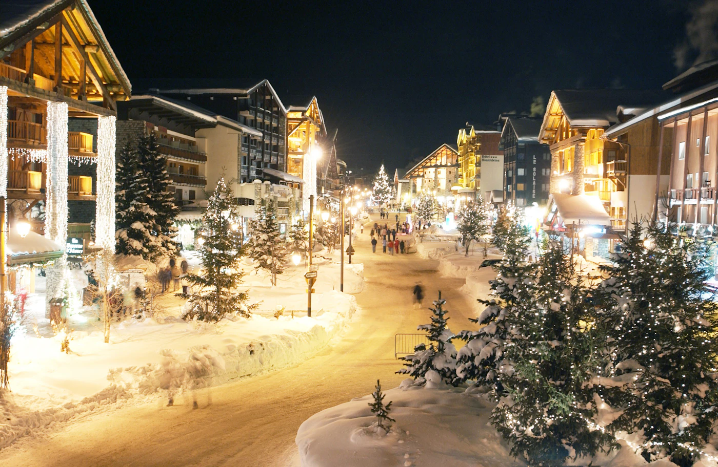 A European city street under Christmas lights, city hotels hold luxury availability far later than resorts