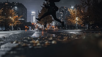 A dynamic action scene from The Living Spectre series showing a shadowy figure leaping through a neon-lit cityscape at night.