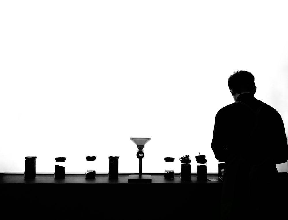 silhouette of man standing in front of table