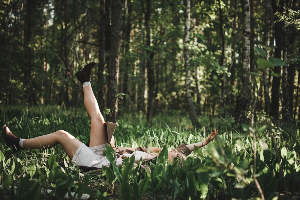 person lying on green grass field during daytime