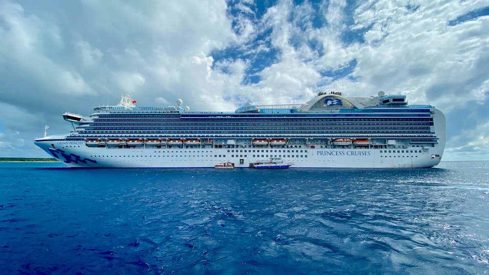 sailing white and blue cruise ship under cloudy sky