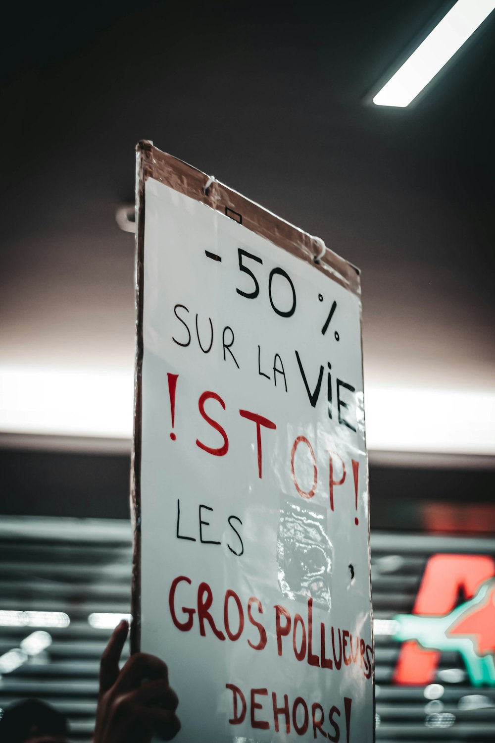 a person holding a sign in a dark room