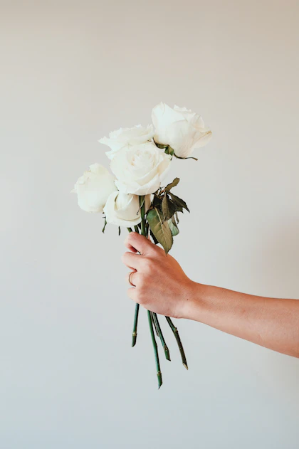 Hand holding white roses — Laurice Manaligod on Unsplash
