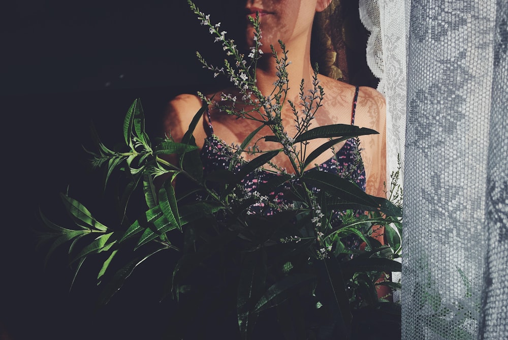 woman standing beside green-leafed plants