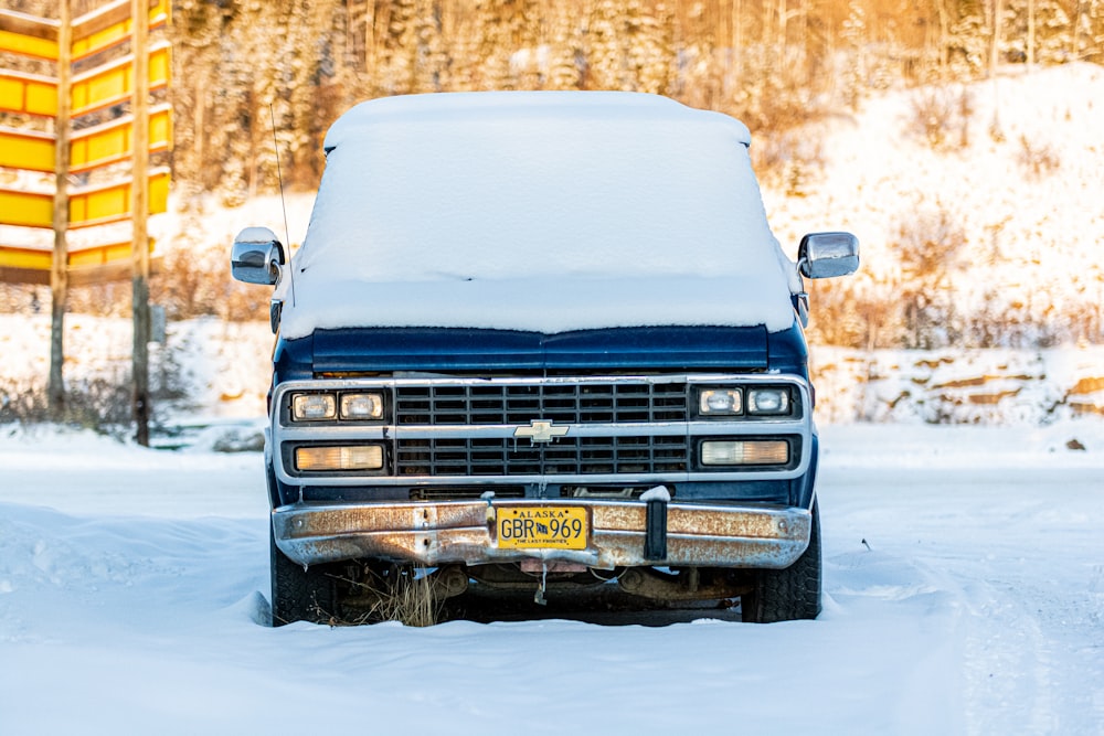 blue Chevrolet vehicle covered with snow