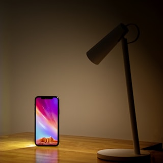 An artistic shot of an Android phone displaying one of tarbud-stroi’s popular apps glowing in a cozy workspace.