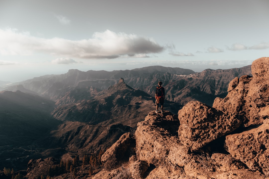 person standing edge of mountain