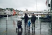 two person with toddler facing body of water