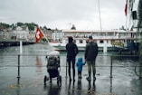 two person with toddler facing body of water