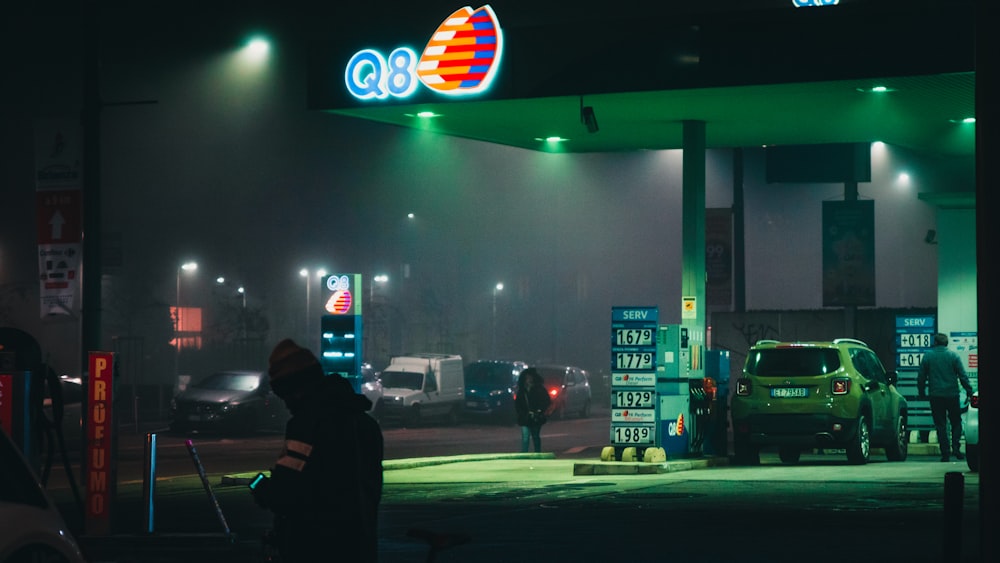 car and people at the Q8 gas station during night