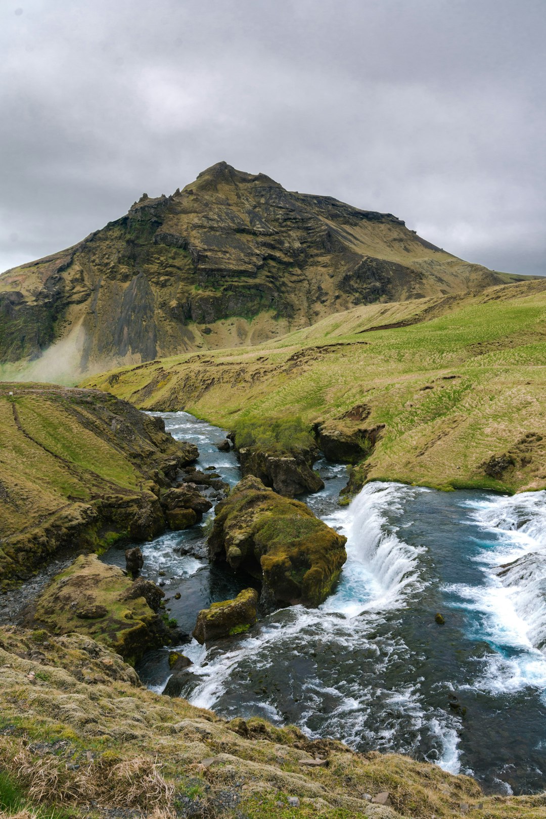 green grassy hill near river