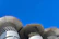 Close-up of a chimney cap being installed on a sunny day with blue skies overhead.