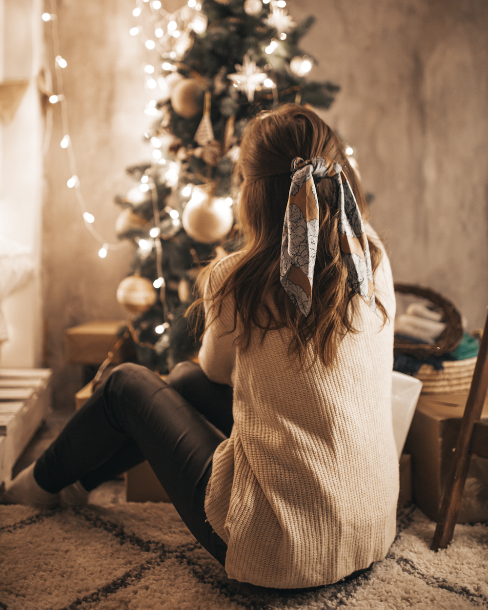 woman sitting near Christmas tree