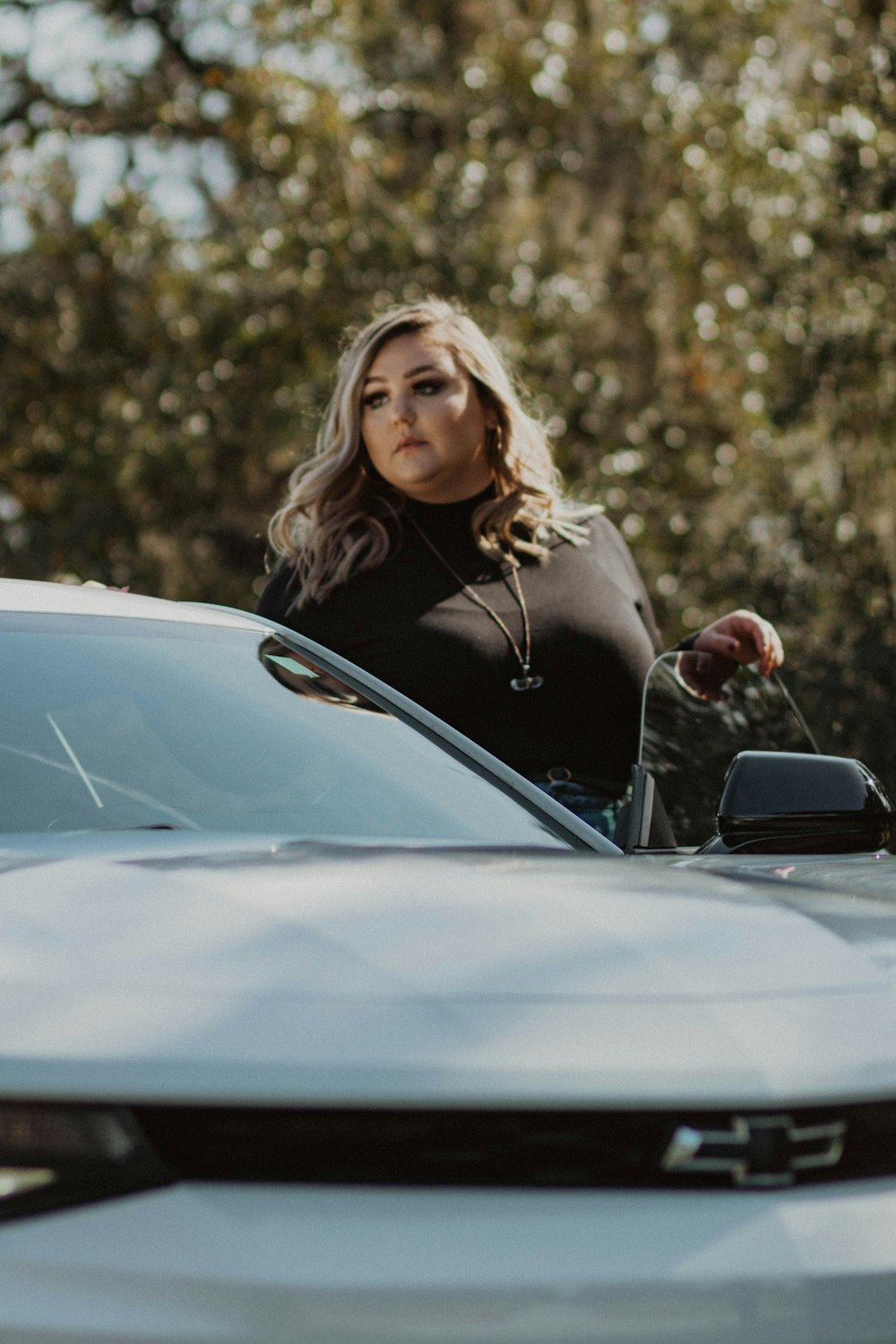 selective focus photography of woman standing beside vehicle