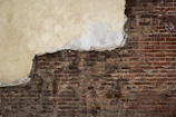 Detail of a moisture-resistant lime plaster patch blending seamlessly on an old farmhouse interior.