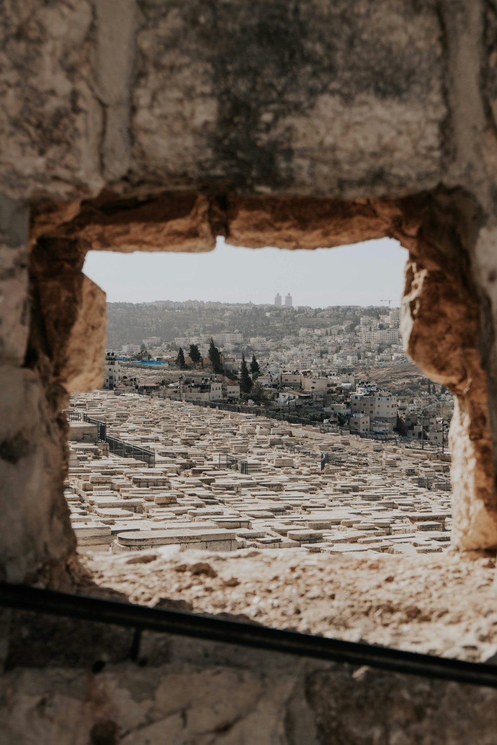 a view of a city through a hole in a stone wall