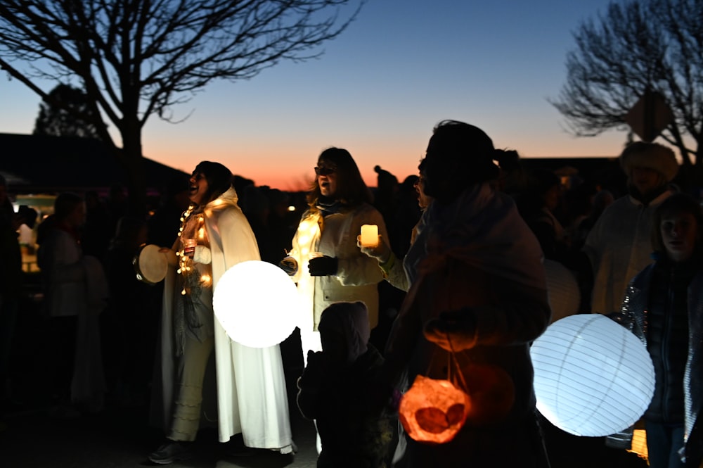 people holding lantern lamps