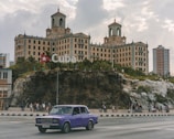 purple sedan on road near building during day