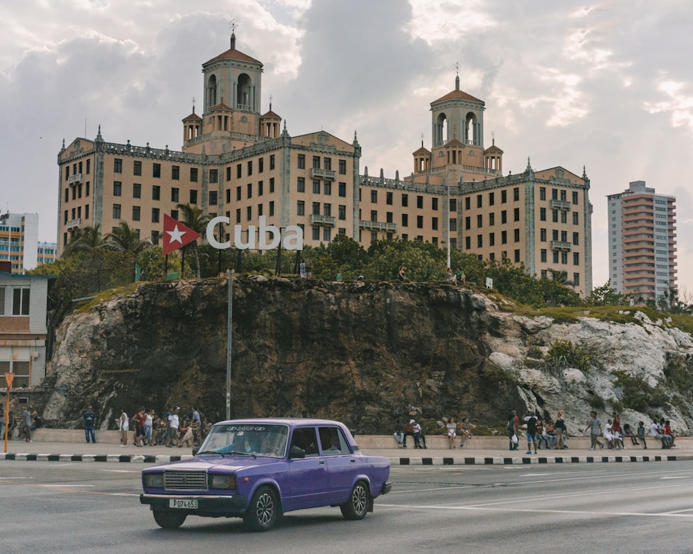 purple sedan on road near building during day