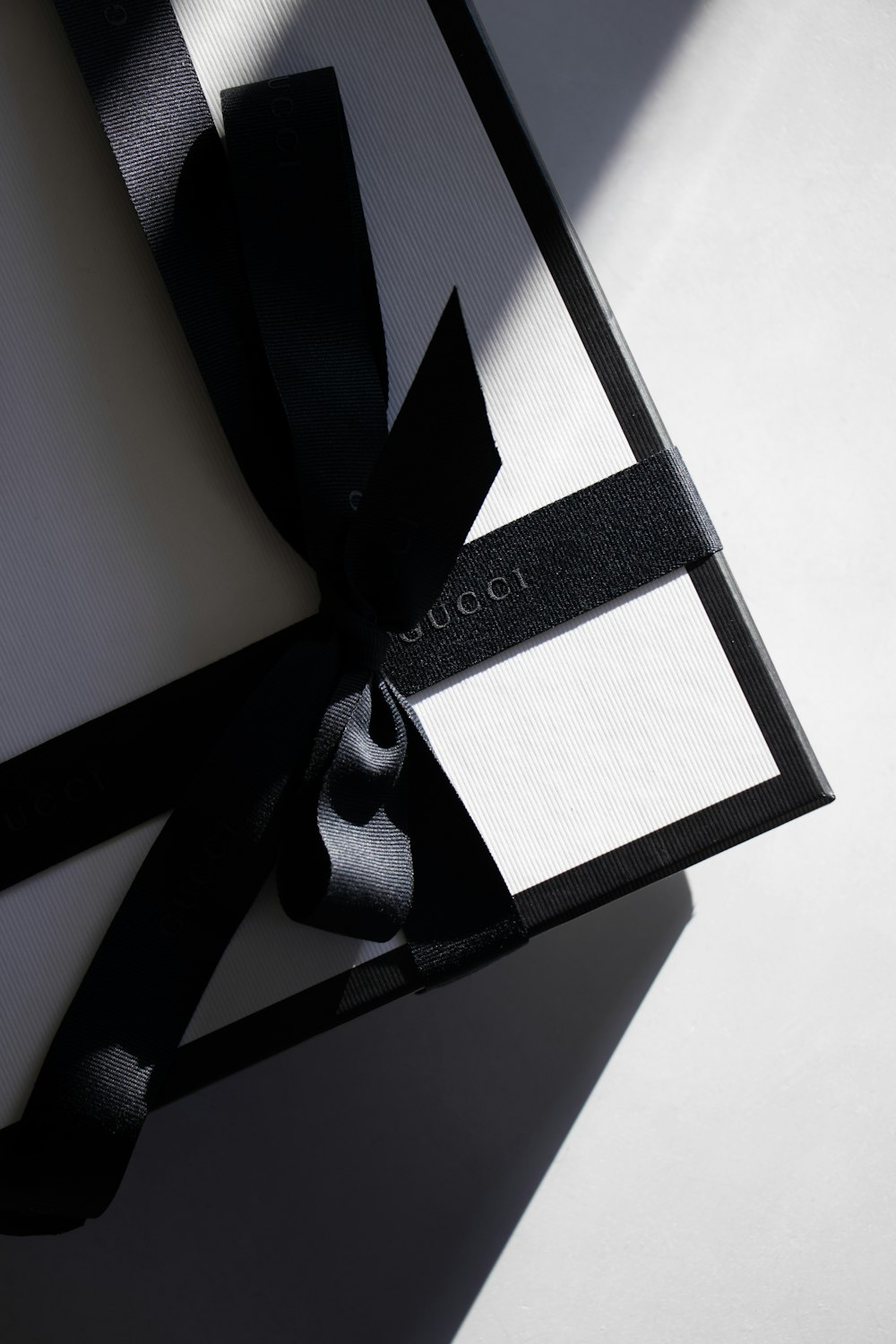 a black and white box with a bow on it