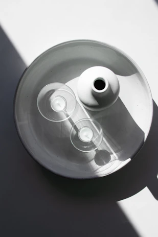Architectural arrangement of sculptural glassware and minimalist cutlery on a white surface.