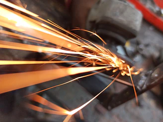 A close-up of a CNC plasma cutting machine in action with sparks flying.