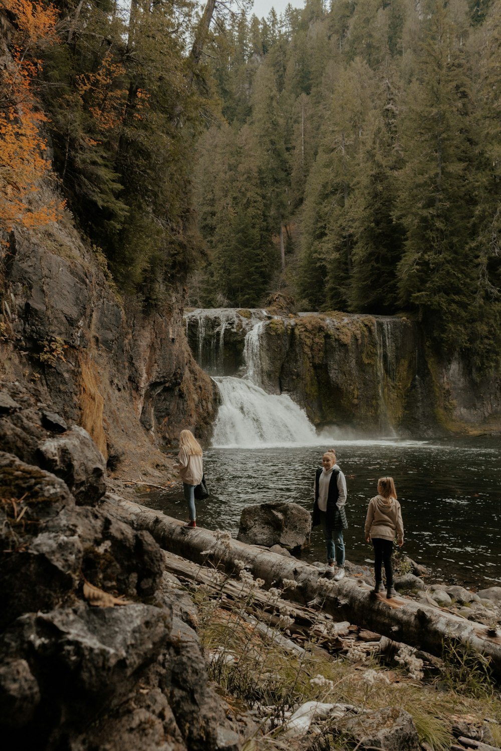 woman and man standing near waterfall
