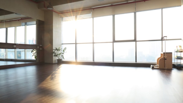 Caregivers helping elderly with light exercise in a bright room.