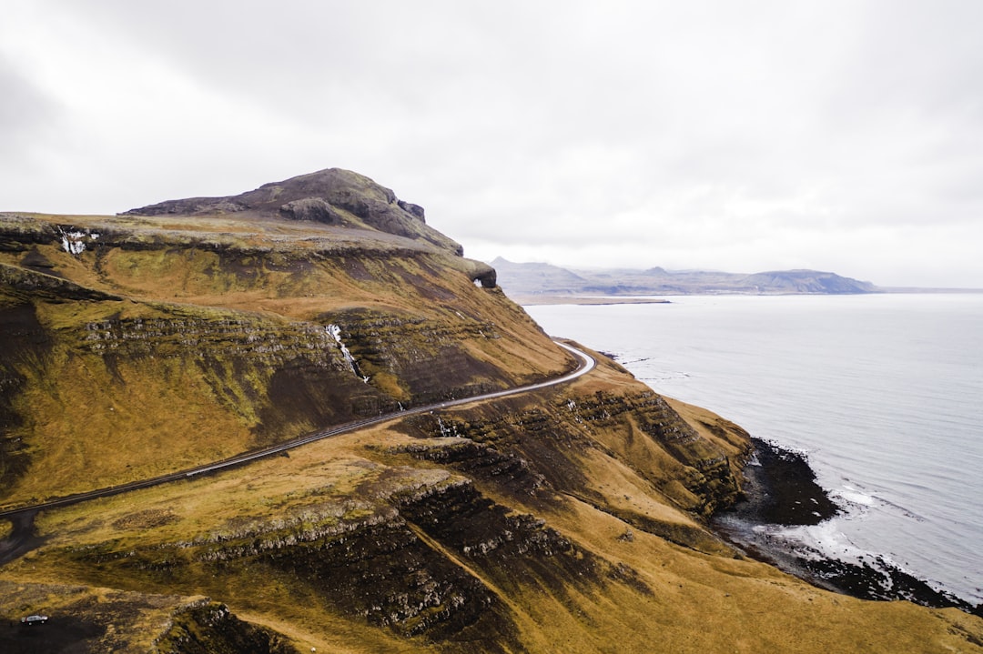 photography of mountain range beside seashore during daytime