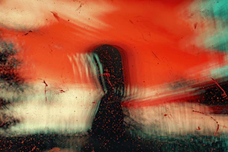 a painting of a person standing in front of a red sky
